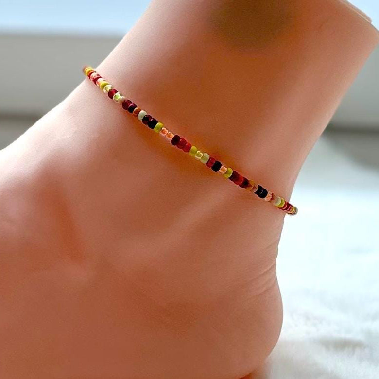 Colorful beaded anklet on a foot with a blurred background