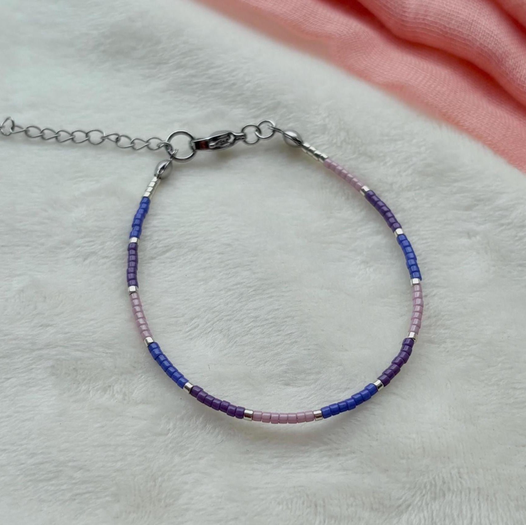 Bracelet with blue and purple beads on a light gray surface