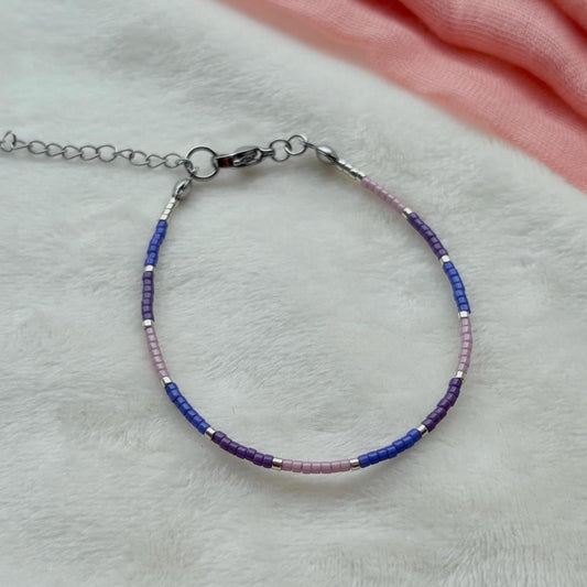 Bracelet with blue and purple beads on a light gray surface