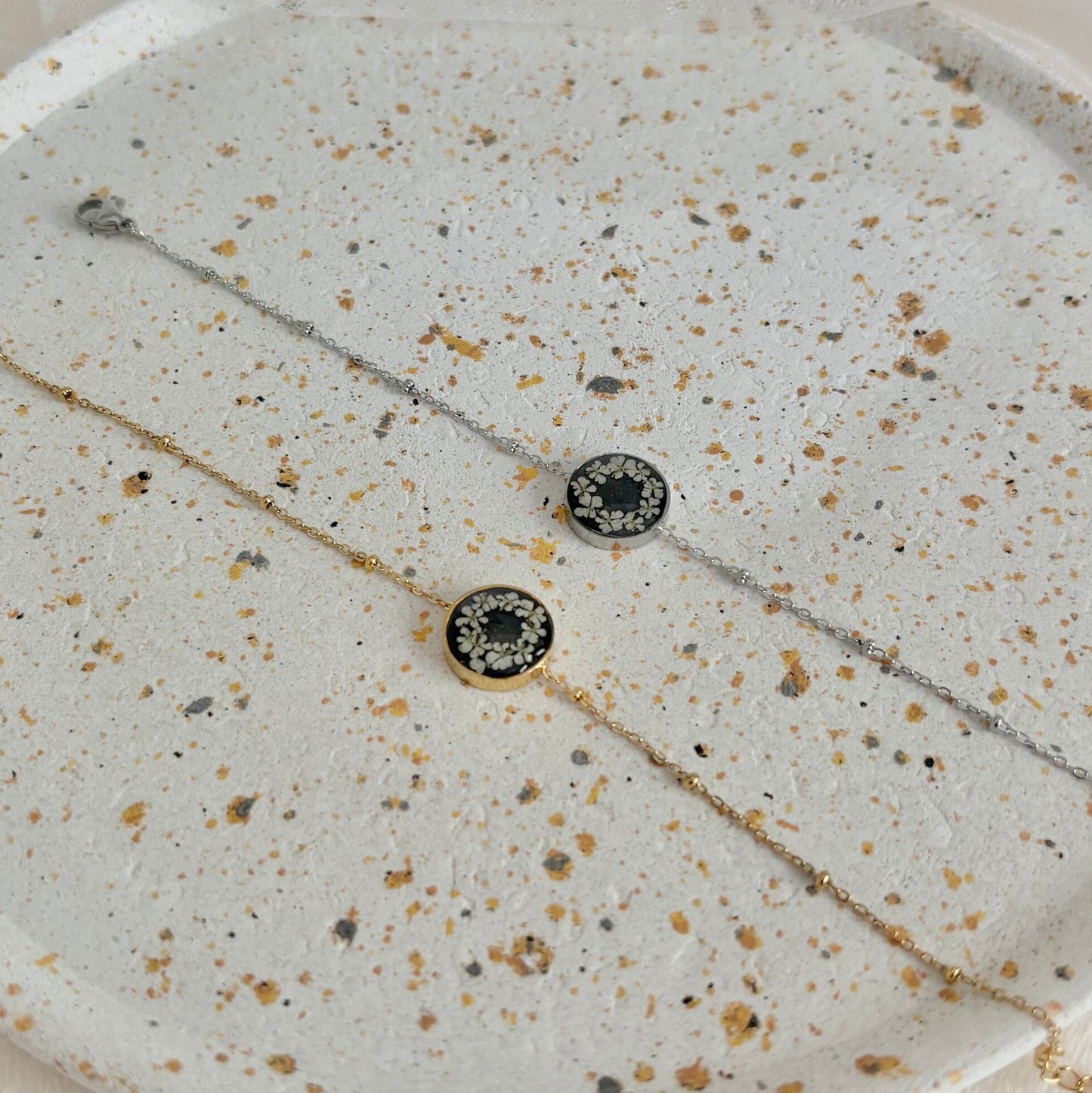 Necklace with black and gold beads on a speckled stone surface