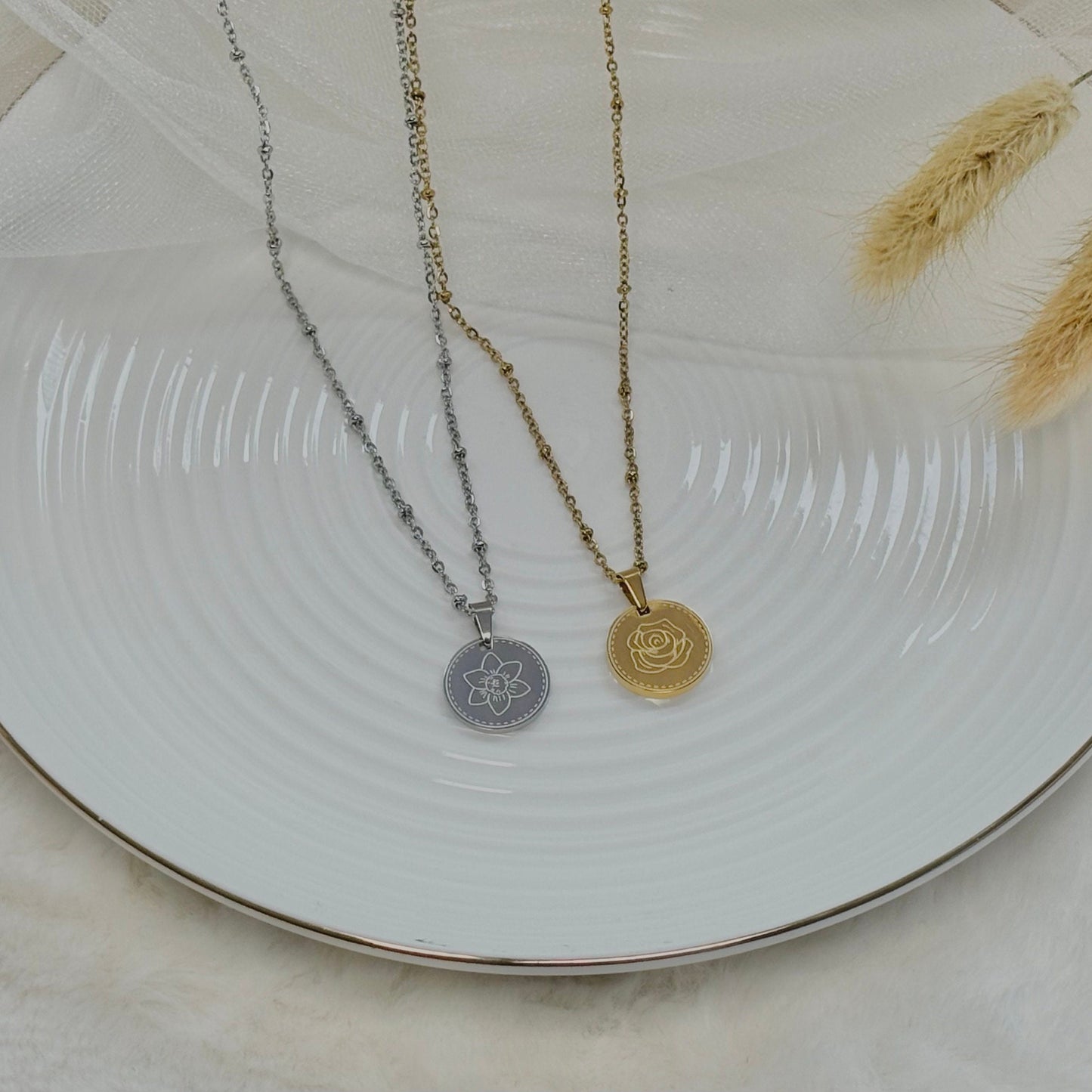 Two necklaces with pendants on a white plate