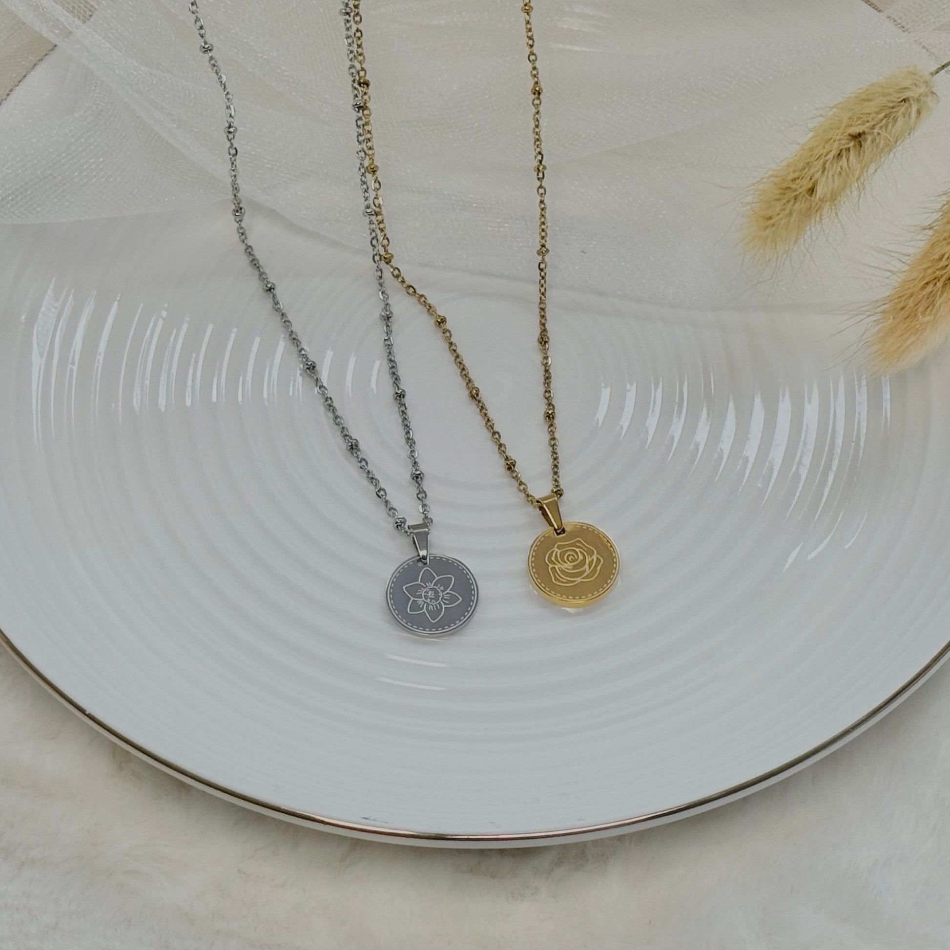 Two necklaces with pendants on a white plate