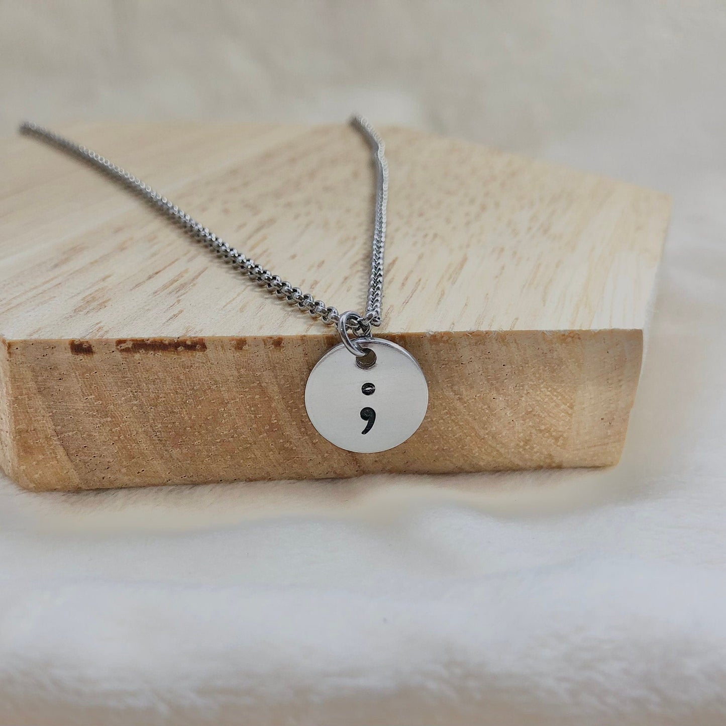 Necklace with a unique pendant on a wooden block