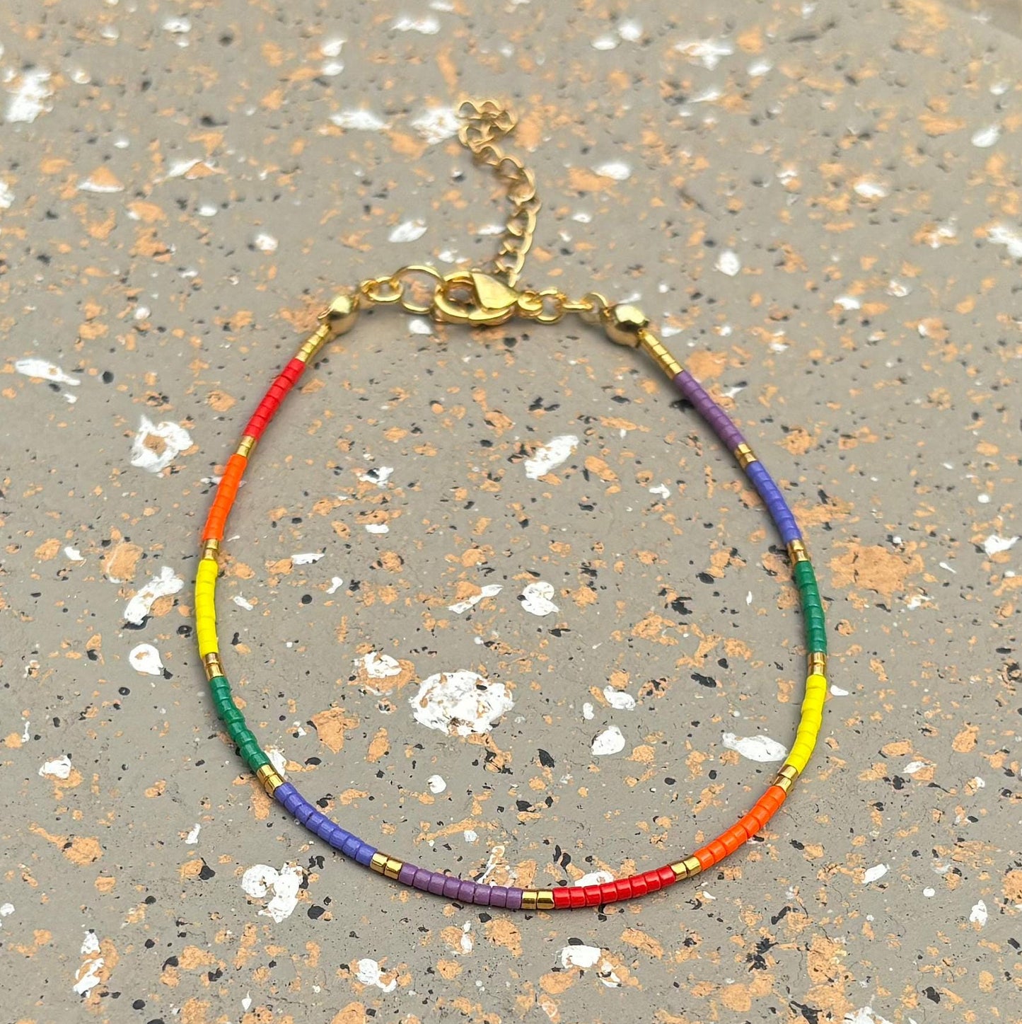 Colorful beaded bracelet on a speckled surface