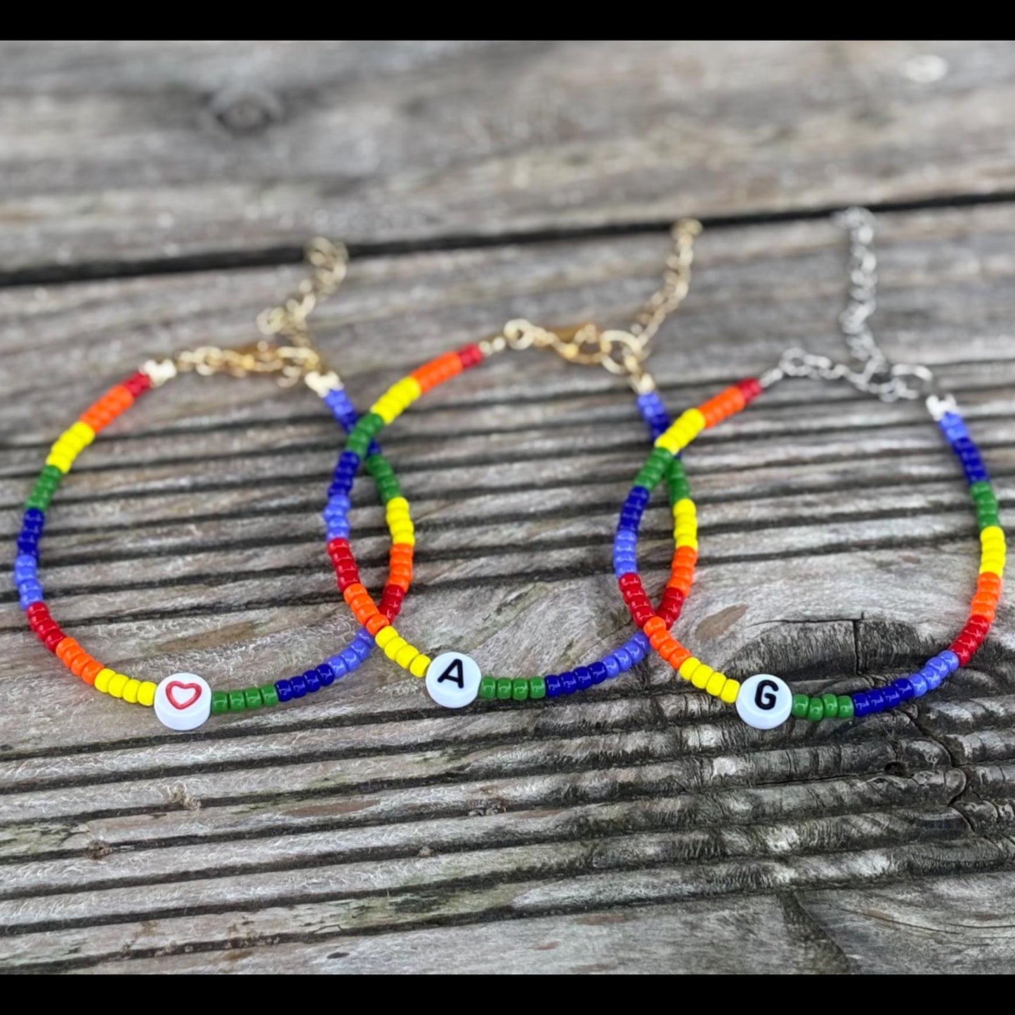 Three colorful beaded bracelets on a wooden surface