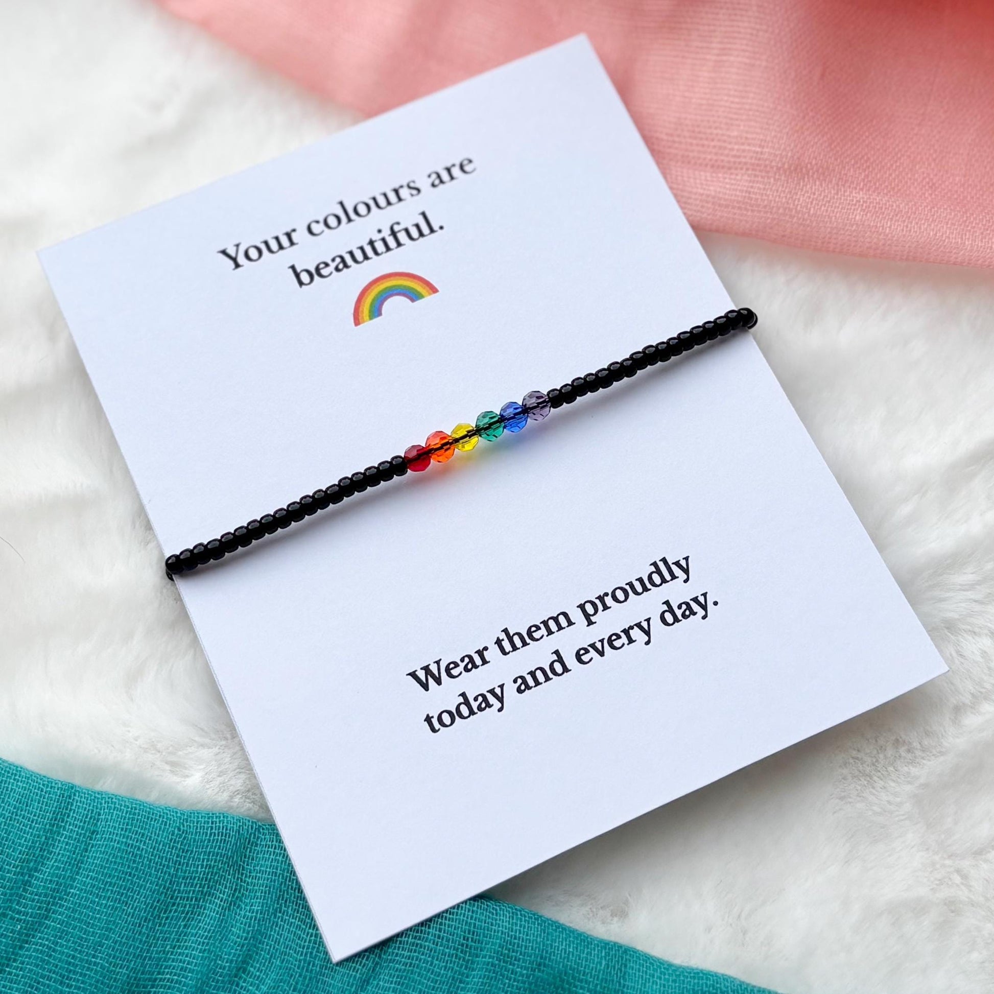 Rainbow bracelet on a card with text on a soft surface