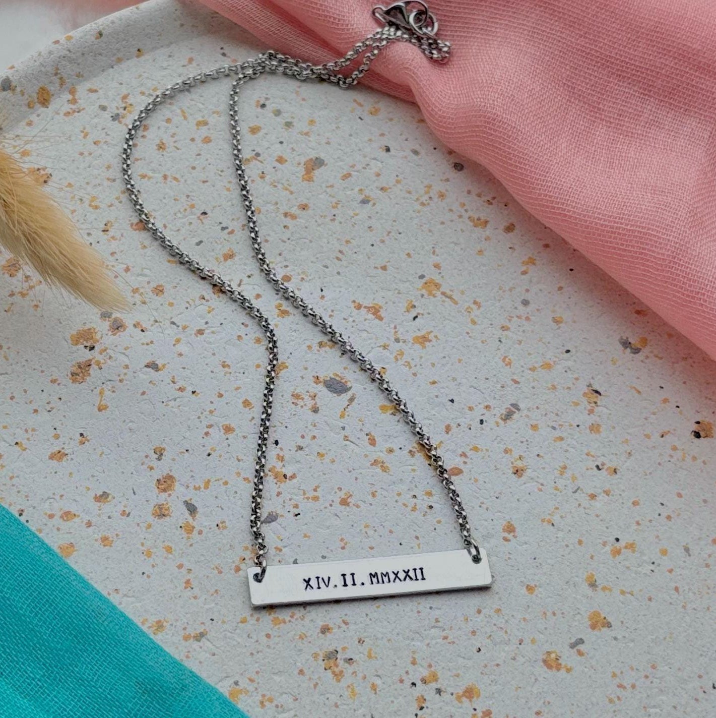Necklace with a engraved pendant on a textured surface